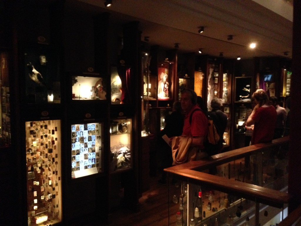 Museets to centrale etager er dunkle og propfyldt med oplyste vægmontrer.