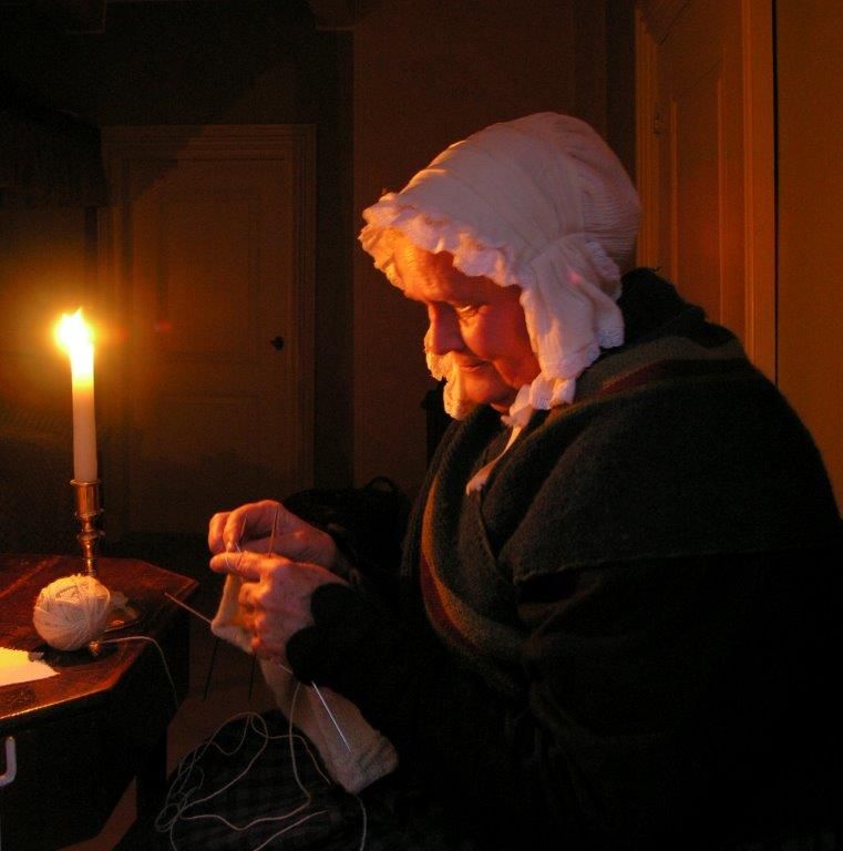 En kvinde sidder og syr ved sterinlys. Hvor hyggeligt, vil mange mene. Ja nok. Men så sandelig også skadeligt for øjnene.