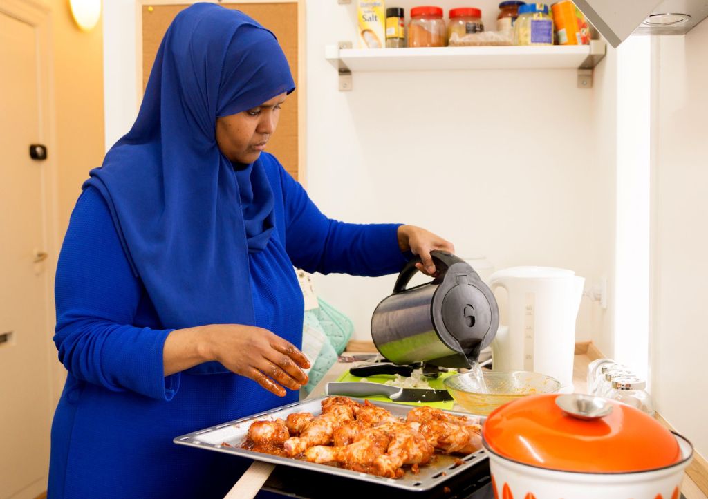 De somaliske kvinder laver jævnligt mad i lejlighedens køkken, hvor der dufter af krydderier som kardemomme, kanel, spidskommen, nelliker, gurkemeje, chili, sort peber og ingefær. Her er Ilham Khalif Mohamed i gang med en kyllingeret.
